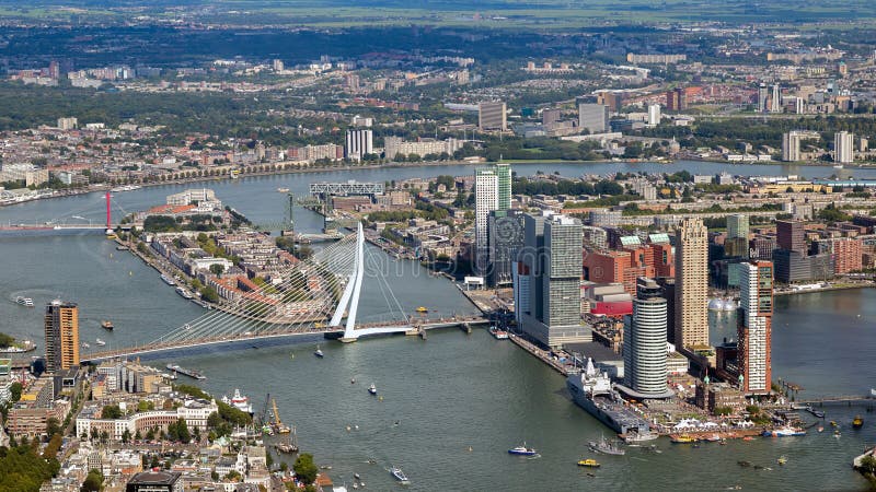 ROTTERDAM, THE NETHERLANDS - SEP 2, 2017: Aerial view of the Meuse river, the Erasmus Bridge and highrise buildings in Rotterdam city. ROTTERDAM, THE NETHERLANDS - SEP 2, 2017: Aerial view of the Meuse river, the Erasmus Bridge and highrise buildings in Rotterdam city.