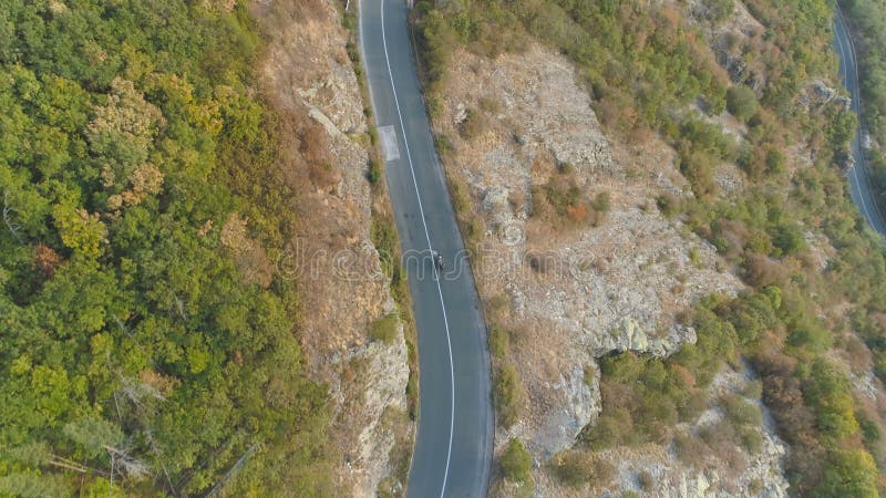 Vue aérienne, drone à la recherche d'une voiture noire à conduite rapide sur une route sinueuse de montagne banque de vidéos