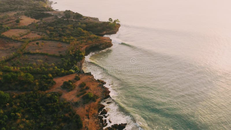 Vue aérienne du cap rocheux et de l'océan avec vagues Paysage avec lumière du coucher ou du lever du soleil banque de vidéos