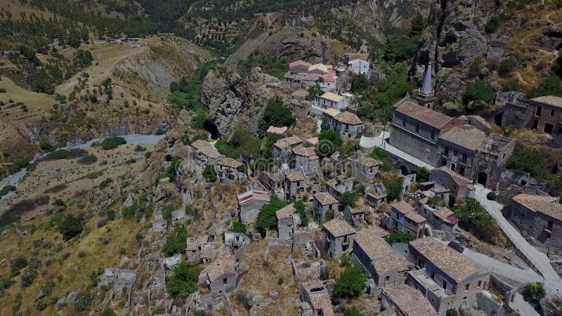 Vue aérienne du petit village de Pentedattilo, d'église et de ruines du village abandonné, colonie grecque sur le bâti Calvario banque de vidéos