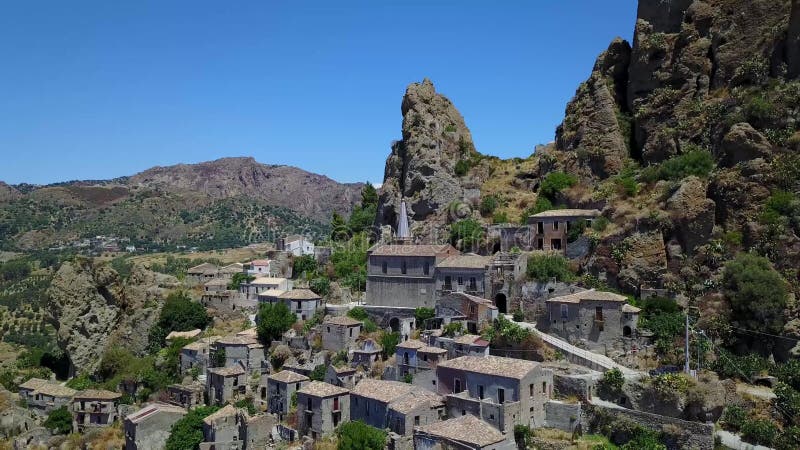 Vue aérienne du petit village de Pentedattilo, d'église et de ruines du village abandonné, colonie grecque sur le bâti Calvario banque de vidéos