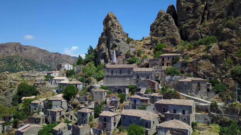 Vue aérienne du petit village de Pentedattilo, d'église et de ruines du village abandonné, colonie grecque sur le bâti Calvario banque de vidéos