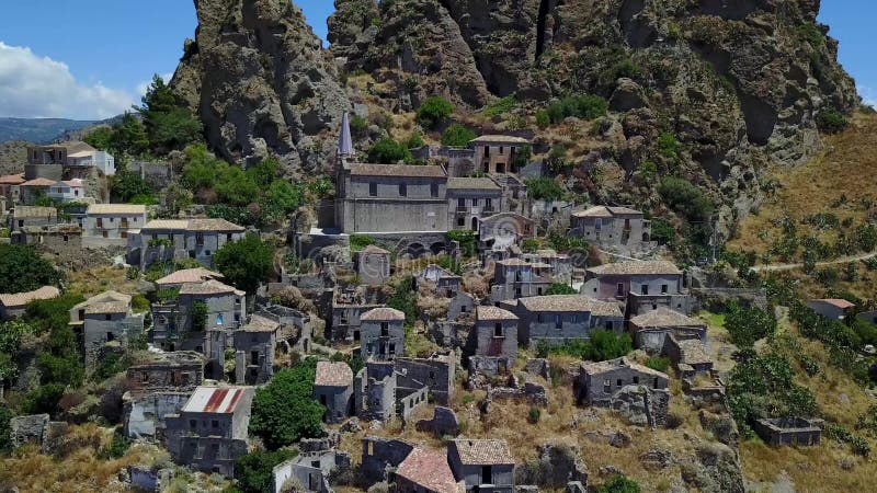 Vue aérienne du petit village de Pentedattilo, d'église et de ruines du village abandonné, colonie grecque sur le bâti Calvario banque de vidéos