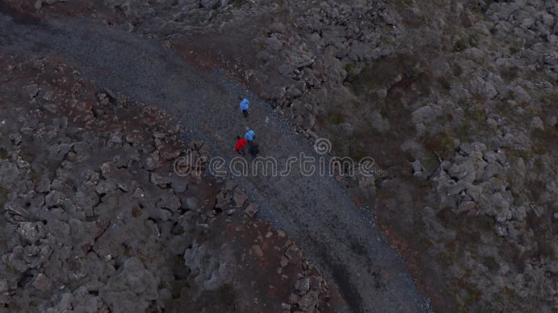 Vue aérienne quatre personnes chemin de marche dans les hautes terres rocheuses désolées en islande. vue panoramique sur les group banque de vidéos