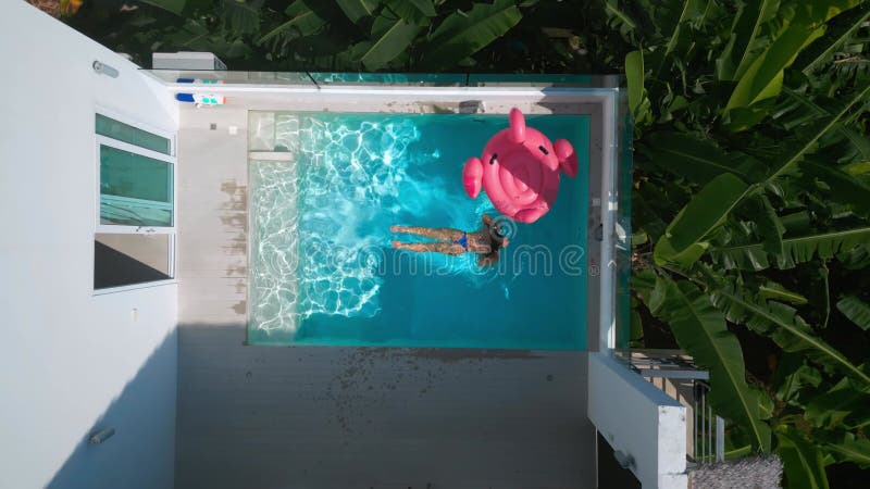 Vue aérienne touriste féminine profitant de la baignade pendant des vacances à la petite piscine. touriste féminine au froid l'été banque de vidéos