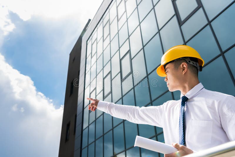 Vue d'angle faible des architectes professionnels dans des masques discutant les hommes d'affaires réussis de projet photo stock