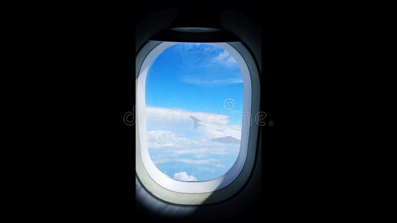 Vue d'une aile d'avion d'un hublot sur fond bleu ciel. un avion de transport vole au-dessus des nuages dans banque de vidéos
