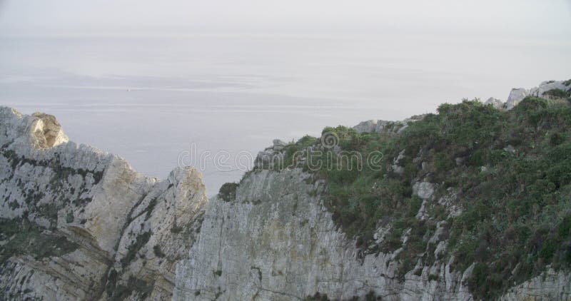 Vue d'une formation des roches près de la mer avec la mer dans le calme dans l'horizon