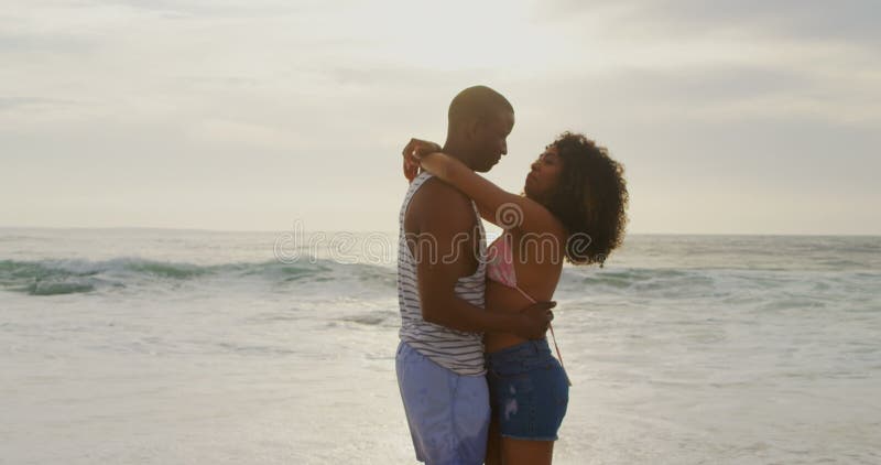 Vue de c? t? de la danse de couples d'Afro-am? ricain ensemble sur la plage 4k clips vidéos