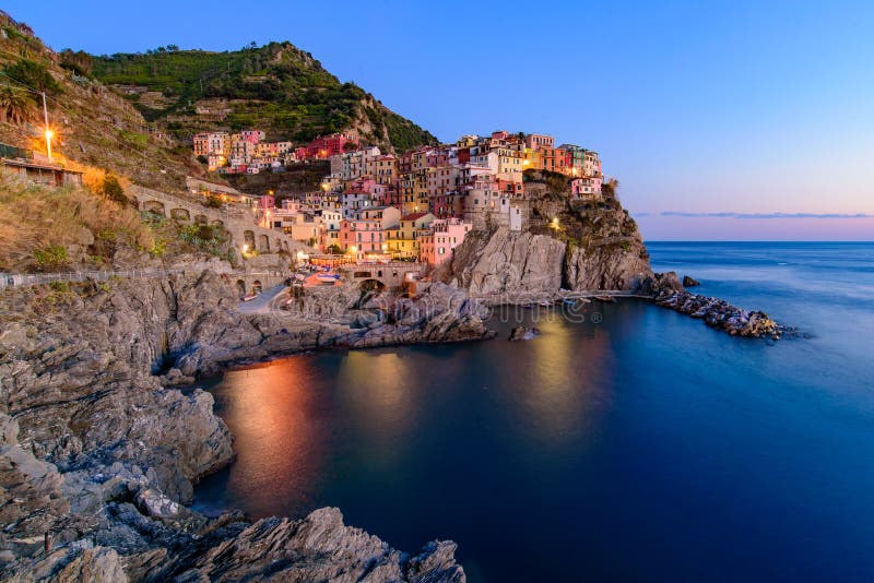 Vue de coucher du soleil et de nuit de Manarola, un des cinq villages méditerranéens en Cinque Terre, l'Italie, célèbre pour ses images stock Vue de coucher du soleil et de nuit de Manarola, un des cinq villages méditerranéens en Cinque Terre, l'Italie, célèbre pour ses images stock