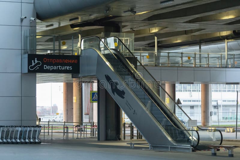 Saint-Petersburg, Russia, 30 April 2020: Empty escalator in Pulkovo International Airport - building exterior. International flights have been cancelled due to coronavirus world pandmic. Saint-Petersburg, Russia, 30 April 2020: Empty escalator in Pulkovo International Airport - building exterior. International flights have been cancelled due to coronavirus world pandmic