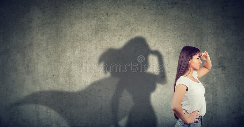 Vue de côté d'une femme imaginant pour être un superhéros semblant aspiré photographie stock