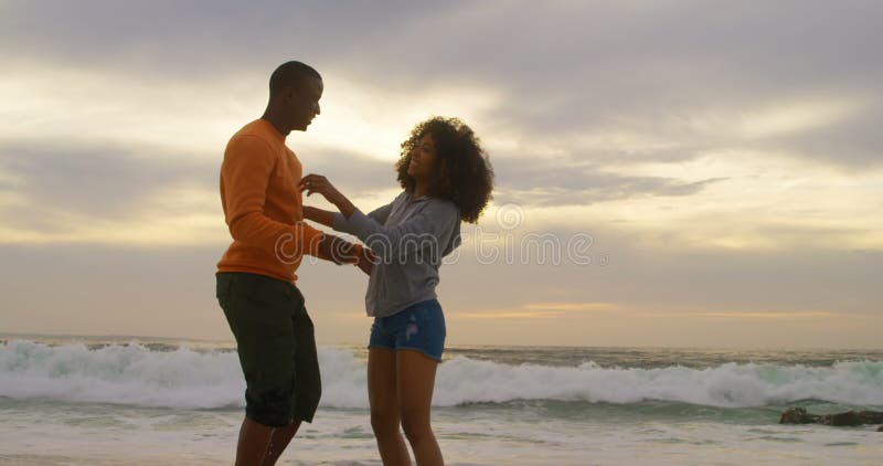 Vue de côté des couples d'Afro-américain s'embrassant sur la plage 4k clips vidéos