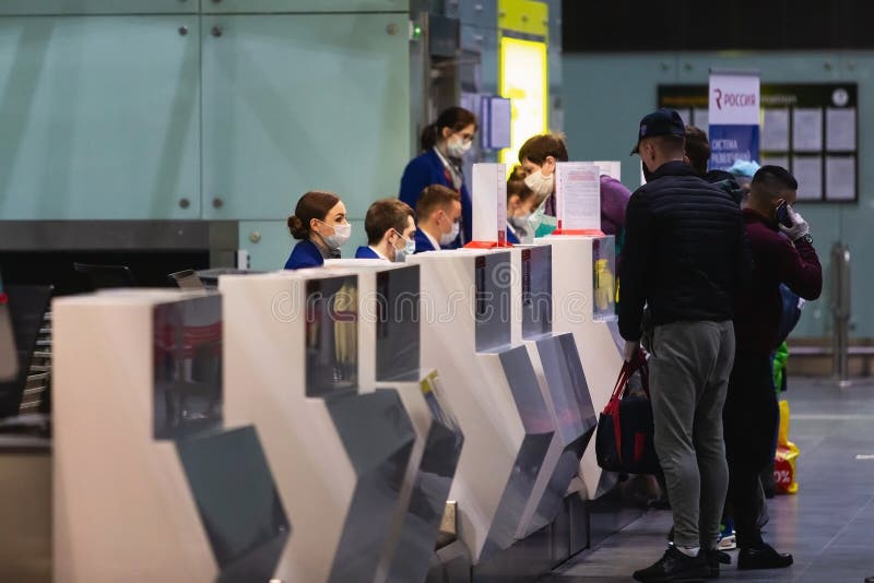 Saint-Petersburg, Russia, 30 April 2020: Registration desk in Pulkovo International Airport. Masked staff check in passengers. International flights canceled due to coronavirus. Saint-Petersburg, Russia, 30 April 2020: Registration desk in Pulkovo International Airport. Masked staff check in passengers. International flights canceled due to coronavirus