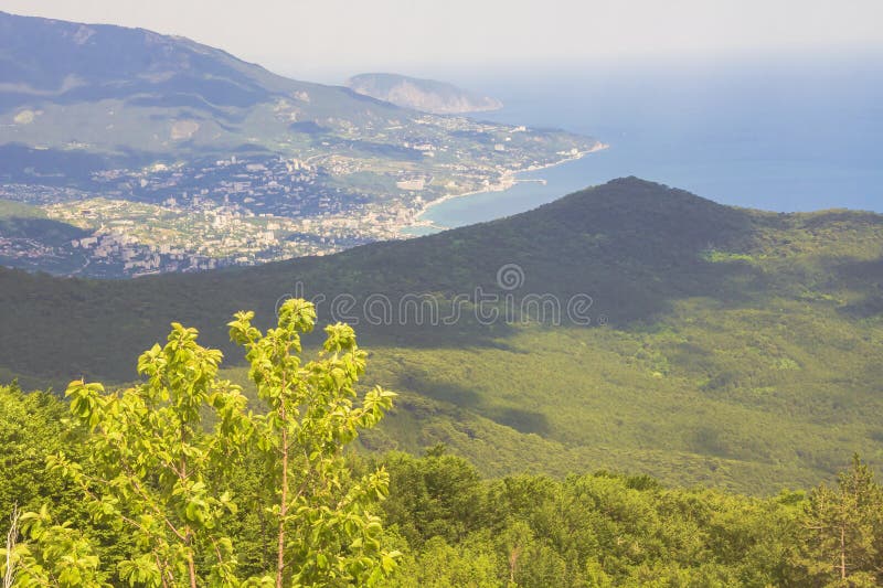 Vue de des montagnes, des arbres, de la mer, de la côte et de la ville loin ci-dessous image libre de droits Vue de des montagnes, des arbres, de la mer, de la côte et de la ville loin ci-dessous image libre de droits