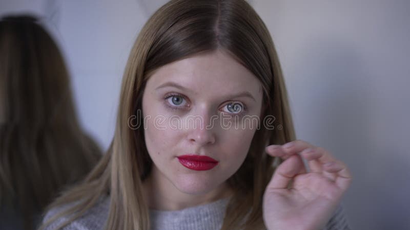 Vue de devant portrait d'une jeune femme merveilleuse et confiante, touchant le visage regarder la caméra. photo de la banque de vidéos