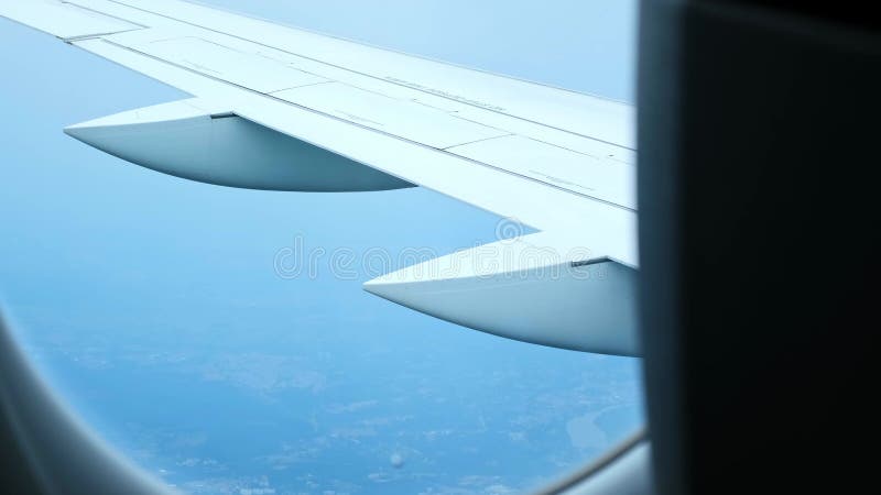 Vue de l'aile de l'aéronef depuis la cabine de l'aéronef à travers le hublot. l'avion décolle au-dessus de la ville. clips vidéos