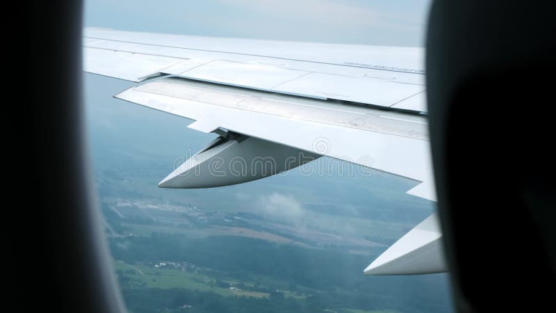 Vue de l'aile d'avion à travers le hublot en vol. Voyage aérien. Crainte des hauteurs. Vue du sol depuis une altitude de vol clips vidéos