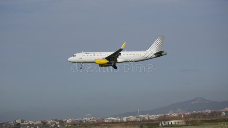 Vue de l'ecmxp de Vueling Airlines Airbus a320 dans l'atterrissage de approche de ciel bleu à l'aéroport EL prat banque de vidéos