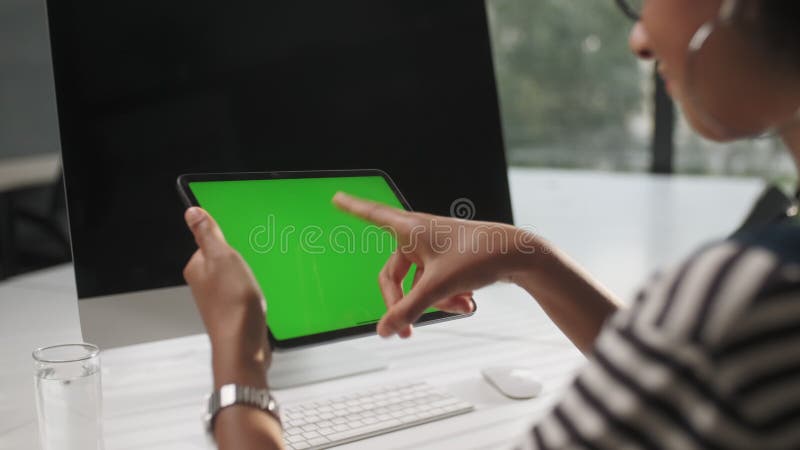 Vue de l'épaulement de la femme retenue et d'utiliser des gestes de la main sur la séance numérique de comprimés d'écran vert prot banque de vidéos