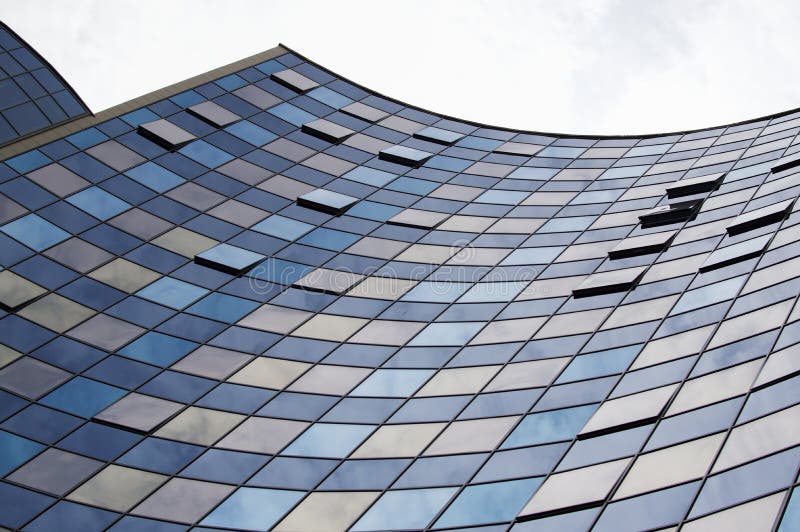 Vue de perspective de la façade en verre moderne de bâtiment avec des réflexions de nuages sur les fenêtres images stock Vue de perspective de la façade en verre moderne de bâtiment avec des réflexions de nuages sur les fenêtres images stock