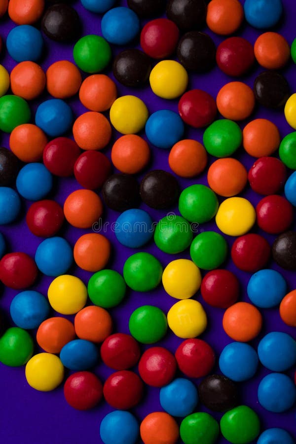 Vue de sucrerie multicolore avec un espace libre sur un fond pourpre photos stock Vue de sucrerie multicolore avec un espace libre sur un fond pourpre photos stock
