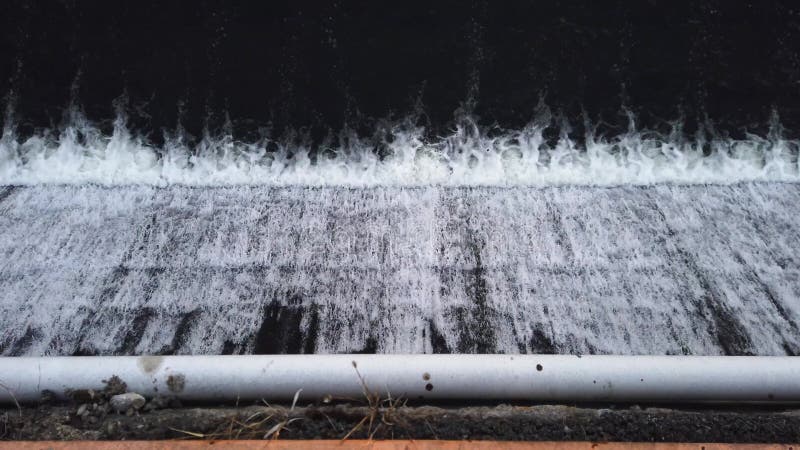 Vue du haut du cours d'eau qui s'écoule au-dessus d'un barrage urbain clips vidéos