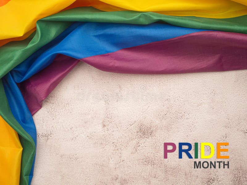 Vue du haut du drapeau arc-en-ciel ou du drapeau LGBT et du texte du mois de la fierté sur un sol en ciment images stock