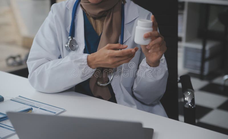 Cropped view of doctor in white coat holding bottle medication, prescribing pills to sick patient via online consultation. Family therapist recommend quality medicines. Healthcare, treatment concept. Cropped view of doctor in white coat holding bottle medication, prescribing pills to sick patient via online consultation. Family therapist recommend quality medicines. Healthcare, treatment concept