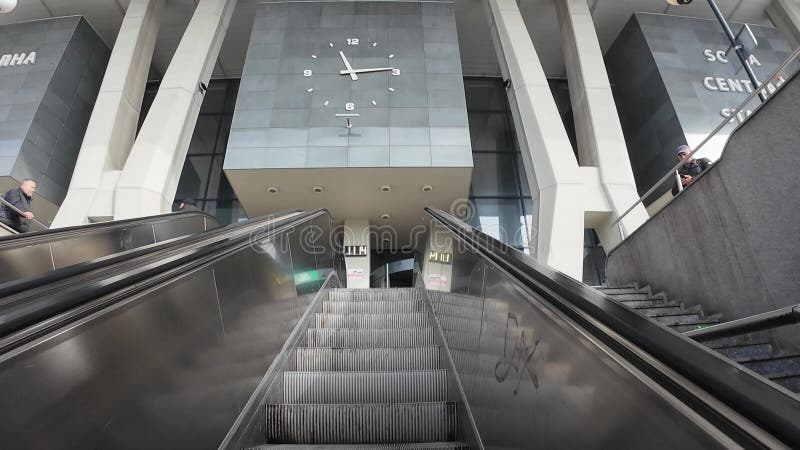 Vue en angle bas de l'escalator ascendant à l'intérieur de la gare centrale de Sofia avec une horloge au-dessus de Sofia clips vidéos