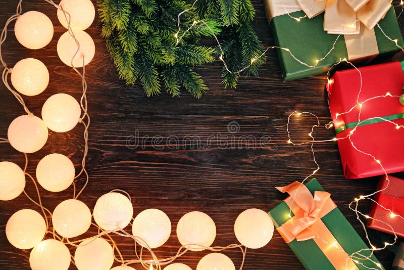 Vue faite de cadeaux de Noël et quirlandes électriques sur le fond en bois image stock Vue faite de cadeaux de Noël et quirlandes électriques sur le fond en bois image stock