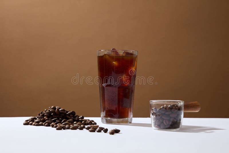 Front view of cup of coffee and coffee beans on brown background. Advertising scene for drink product. Active caffeine in coffee makes you awake, refreshed and work more focused. Front view of cup of coffee and coffee beans on brown background. Advertising scene for drink product. Active caffeine in coffee makes you awake, refreshed and work more focused