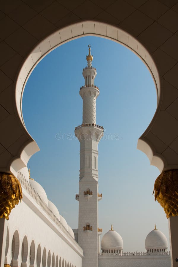 Vue grande de minaret de mosquée de l'Abu Dhabi par l'arcade image libre de droits Vue grande de minaret de mosquée de l'Abu Dhabi par l'arcade image libre de droits