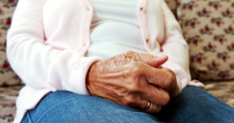 Vue haute étroite d'extrémité de personne retraitée frottant ses mains ensemble banque de vidéos