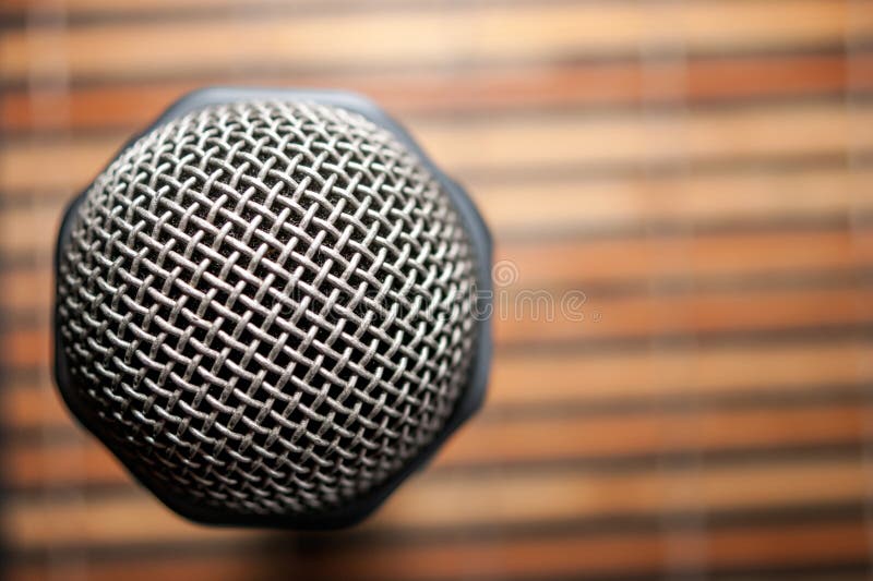 Vue hiérarchisée d'une tête de microphone et d'un gril argenté sur un jaune rayé et un bambou noir Mat Background Bar karaoke Cop photographie stock Vue hiérarchisée d'une tête de microphone et d'un gril argenté sur un jaune rayé et un bambou noir Mat Background Bar karaoke Cop photographie stock