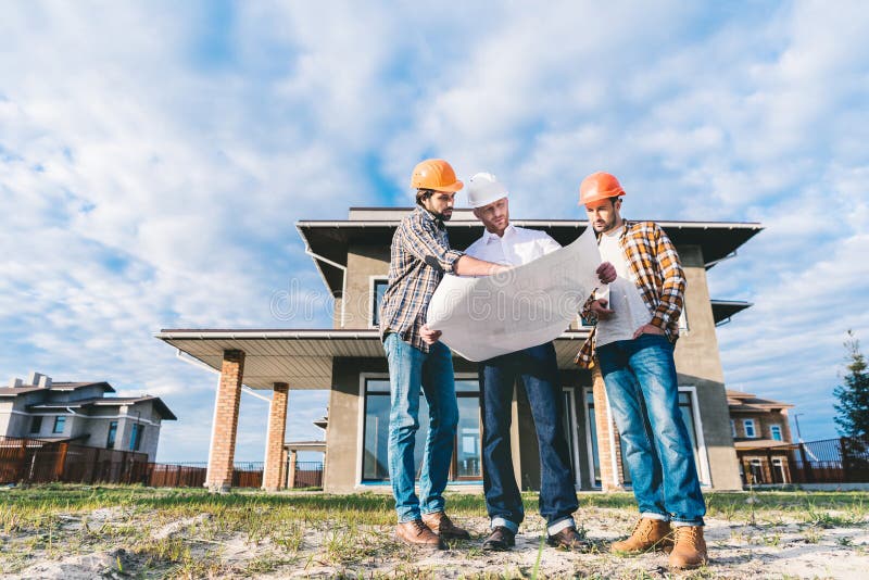 Vue inférieure du groupe d'architectes avec le modèle dans le jardin photo stock