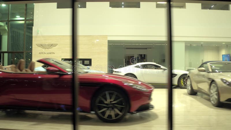 Vue intérieure de concessionnaire automobile de luxe du vitrail et le jaguar Aston Martin à West Palm Beach en Floride de nuit clips vidéos