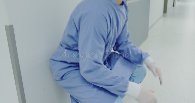 Vue latérale d'un médecin caucasien inquiet marchant dans le couloir banque de vidéos