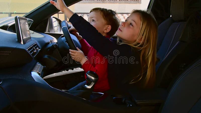 Vue latérale de la fille de 8 ans, garçon de 4 ans jouant au simulateur de voiture clips vidéos