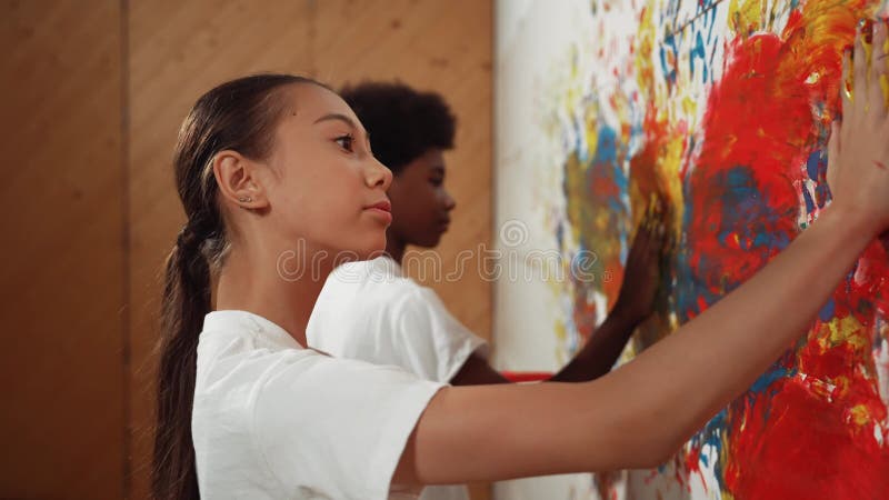 Vue latérale de la fille mettre la main en aquarelle et timbre sur le mur. édification banque de vidéos