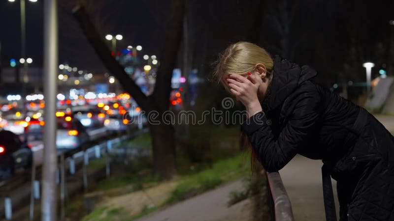 Vue latérale. une jeune fille solitaire se sent déprimée debout sous un pont. épuisement émotionnel. santé mentale banque de vidéos