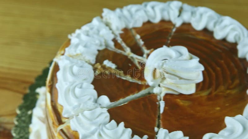 Vue panoramique de gros plan du gâteau rond en tranches de caramel décoré de la crème blanche banque de vidéos