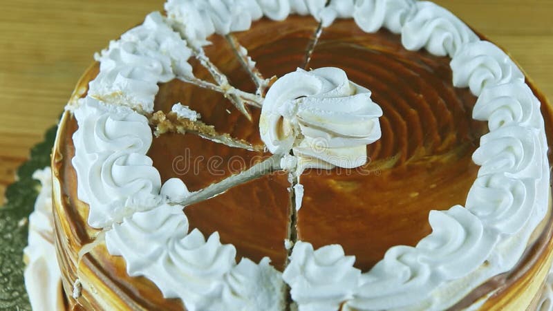 Vue panoramique de gros plan du gâteau rond en tranches de caramel décoré de la crème blanche banque de vidéos