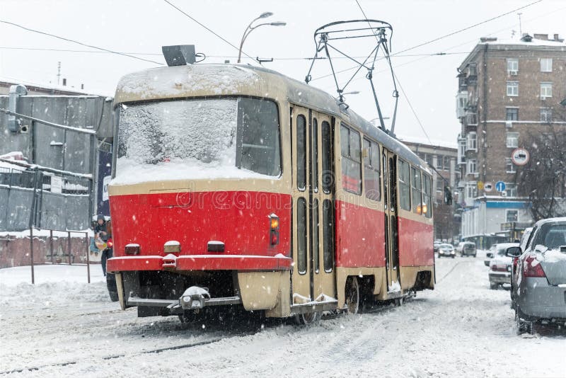 Vue panoramique de vieux tram rétro tram conduisant rues enneigées de la ville de kiev avec trafic à forte chute de neige blizzard