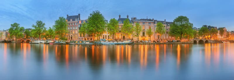 Vue panoramique et paysage urbain d'Amsterdam avec des bateaux, de vieux bâtiments et la rivière d'Amstel, Hollande, Pays-Bas photographie stock libre de droits Vue panoramique et paysage urbain d'Amsterdam avec des bateaux, de vieux bâtiments et la rivière d'Amstel, Hollande, Pays-Bas photographie stock libre de droits