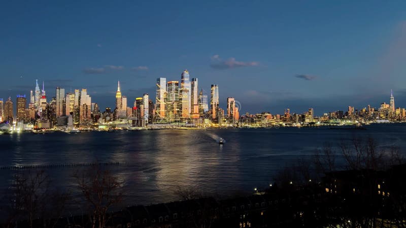 Vue postsunset du Midtown Manhattan de Weehawken NJ. Ferry sur Hudson River reflets dorés sur gratte-ciel. Éditorial. banque de vidéos