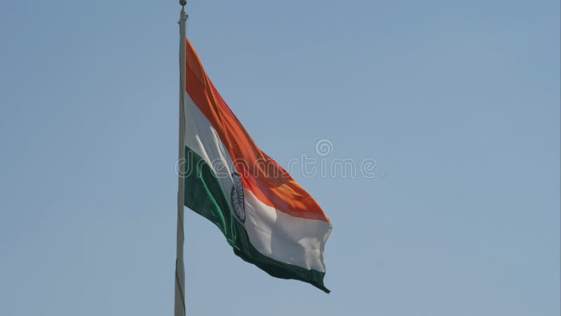 Vue rapprochée au ralenti d'un drapeau indien géant qui vole magnifiquement par jour brillant avec ciel bleu clair en arrière-plan banque de vidéos