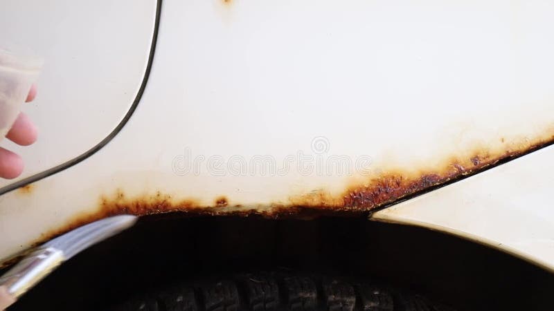 Vue rapprochée de la personne appliquer à la maison utilisation voiture antirouille liquide sur le véhicule. banque de vidéos