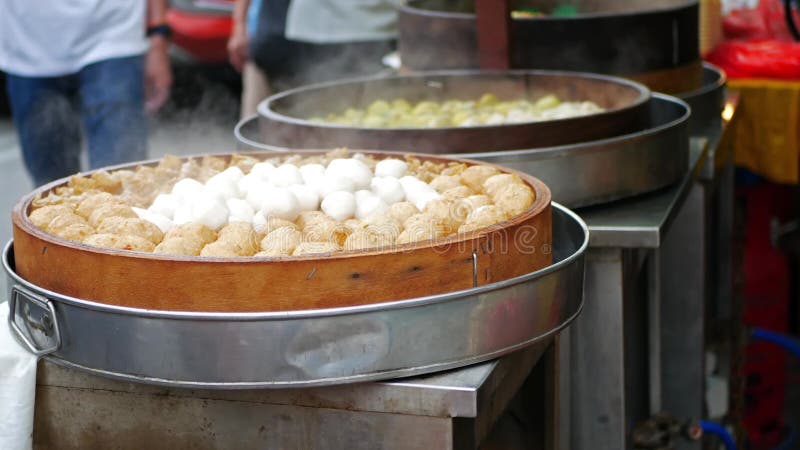 Vue rapprochée des boules de poissons et dim sum en bambou vapeur qui se vend à côté de la rue banque de vidéos