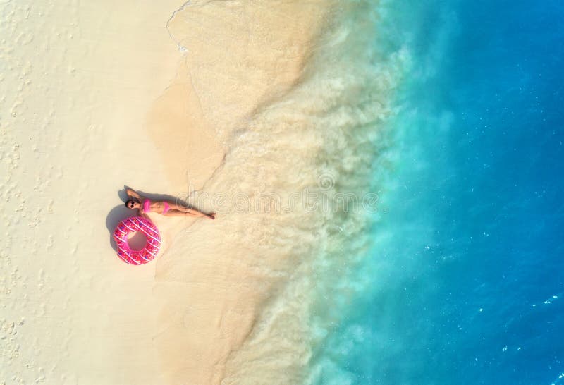 Vue a?rienne de femme avec l'anneau de bain sur la plage sablonneuse photo stock Vue a?rienne de femme avec l'anneau de bain sur la plage sablonneuse photo stock